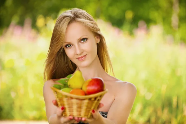 Portrait of woman holding a basket of fruit — Stock Photo, Image