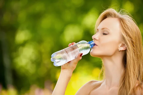 Женщина пьет бутылку воды — стоковое фото