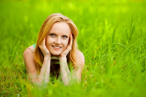 Beautiful young smiling woman lying green grass — Stock Photo, Image
