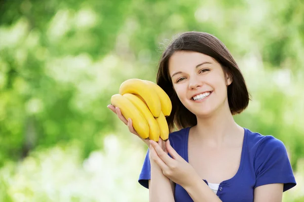 Молодая женщина держит бананы — стоковое фото