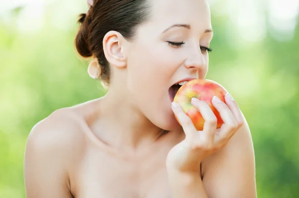 Mujer desnuda joven comiendo una manzana — Foto de Stock