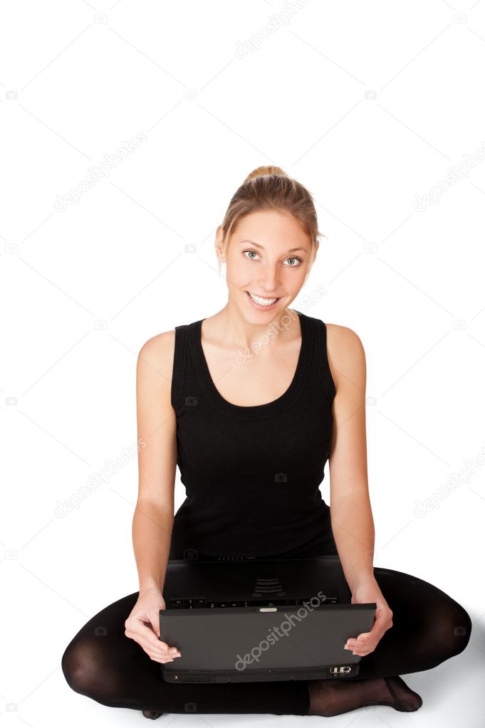Smiling yong woman sitting on floor with laptop isolated on whit