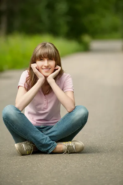 ロータス ポーズ道路上に座っている若い美しい女性 — ストック写真