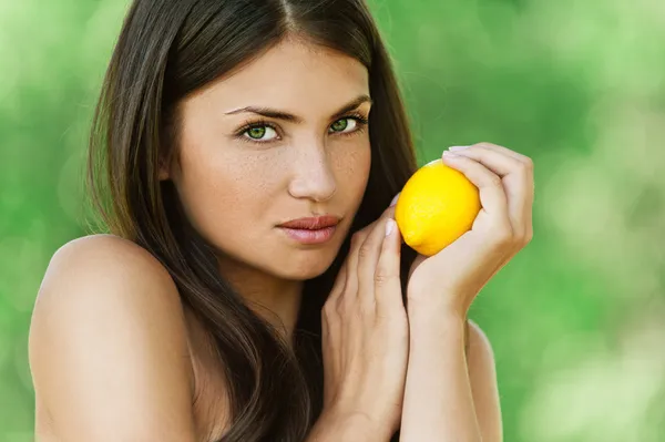 Beautiful young woman holding lemon — Stock Photo, Image