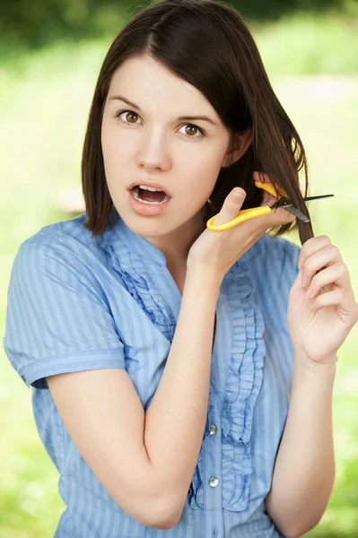 Jonge vrouw snijden haar haren — Stockfoto