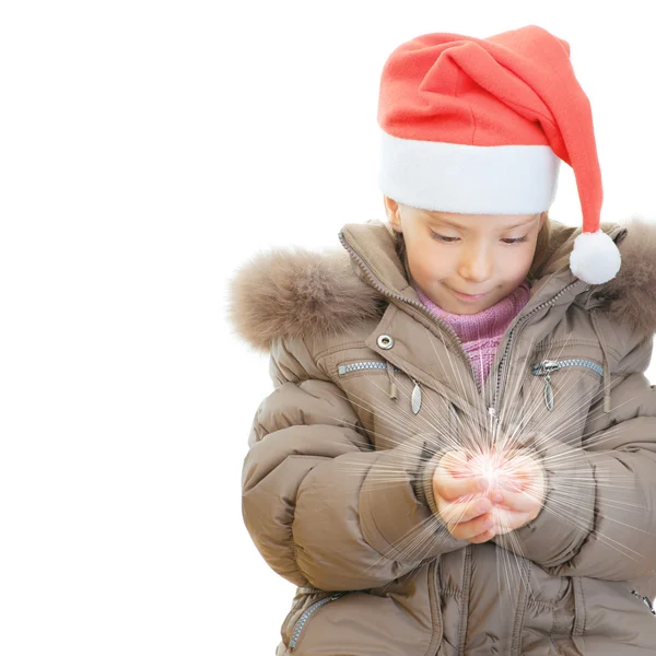 Kleines Mädchen Weihnachtsmütze hält leuchtende Kugel — Stockfoto
