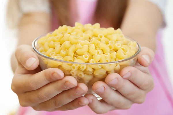 Weinig meisje bedrijf kom met pasta — Stockfoto