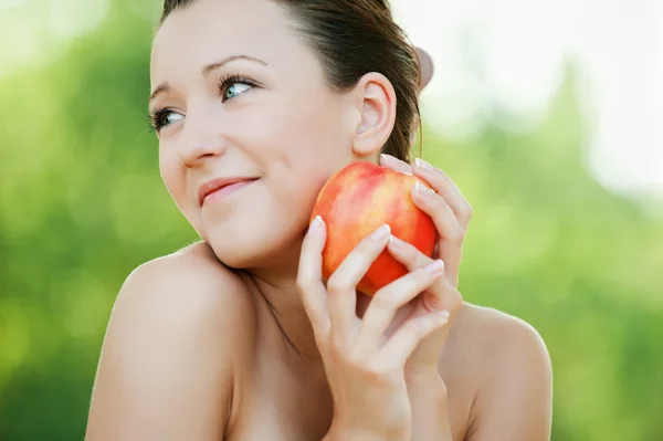 Молода усміхнена жінка тримає яблуко — стокове фото
