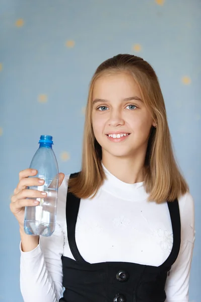 Leende flicka-tonåring anläggning flaska — Stockfoto