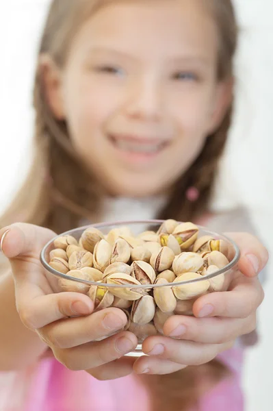 Little girl holding bowl with pistachios — Stock Photo, Image