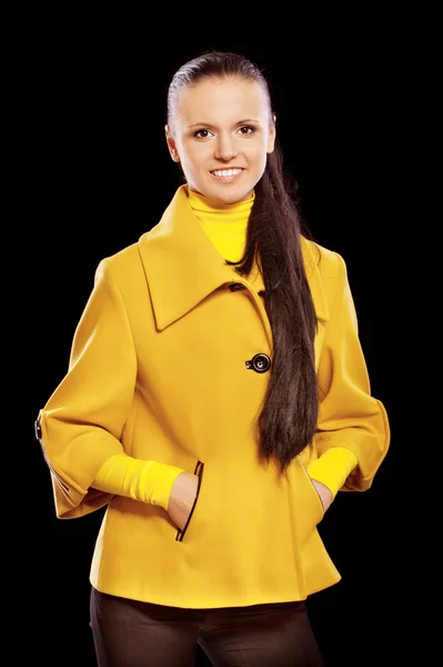 Молода красива жінка в жовтих пальто — стокове фото