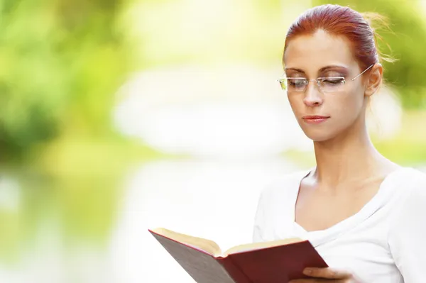 Όμορφη γυναίκα διαβάζει το βιβλίο προσεκτικά — Φωτογραφία Αρχείου