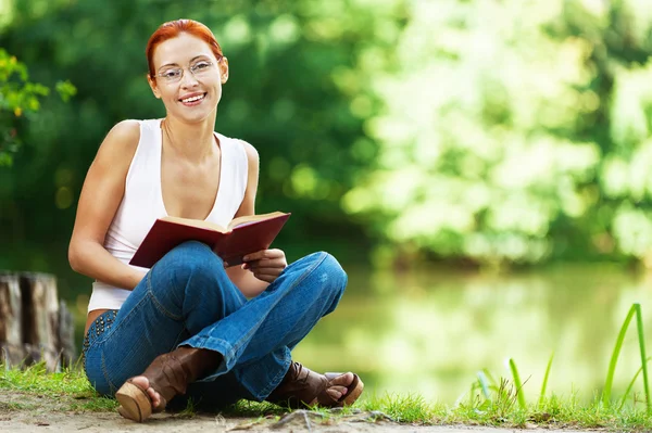 Bella donna seduta a terra con libro — Foto Stock