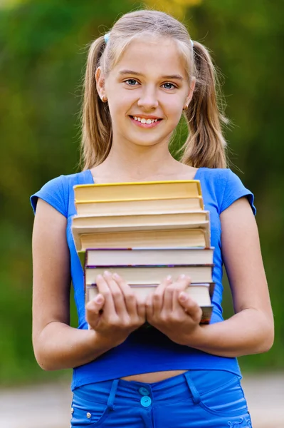 Adolescente chica sosteniendo pila de siete libros — Foto de Stock