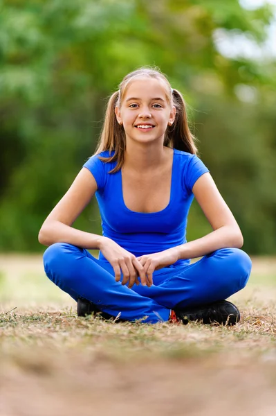 Dospívající dívka sedící v lotosové pozici — Stock fotografie