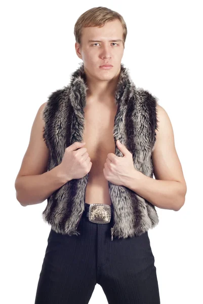 Young handsome man posing in studio in fur waistcoat — Stock Photo, Image