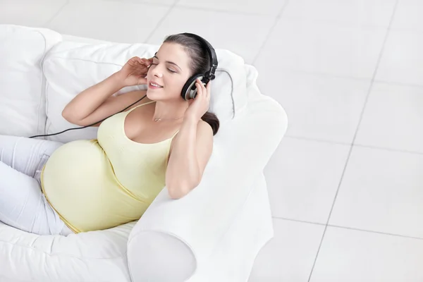 Kobieta w ciąży ze słuchawkami — Zdjęcie stockowe