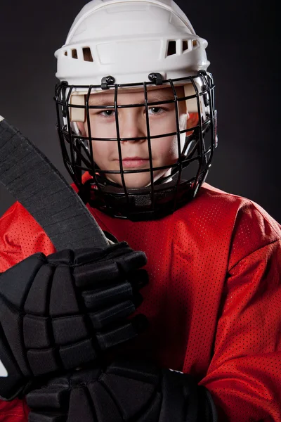 Retrato de un joven jugador de hockey sobre hielo sobre fondo oscuro — Foto de Stock