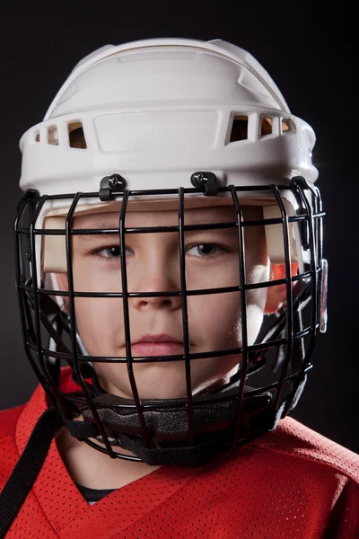 在黑暗的背景上一个年轻冰上曲棍球球员的肖像 — 图库照片
