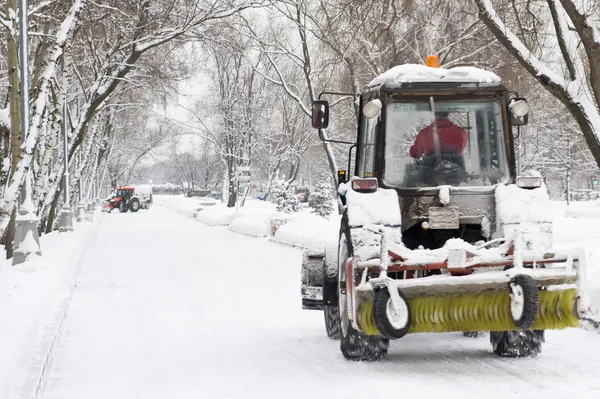 Schneeräumung mit einem kleinen Traktor im Park — Stockfoto