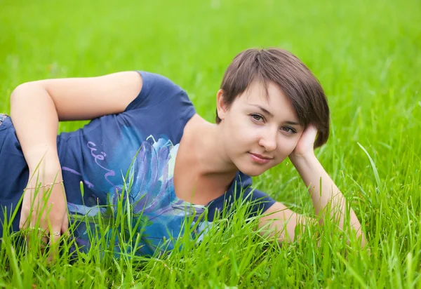 Fiatal nő bágyasztó-ra-a zöld fű — Stock Fotó