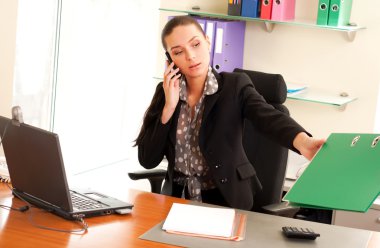 Business woman sitting in the office in front of the laptop and clipart