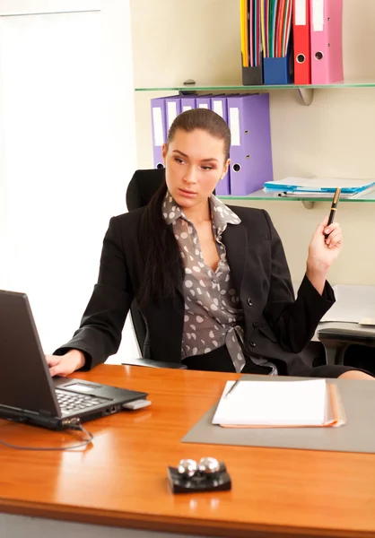 Деловая женщина сидит в офисе перед ноутбуком — стоковое фото
