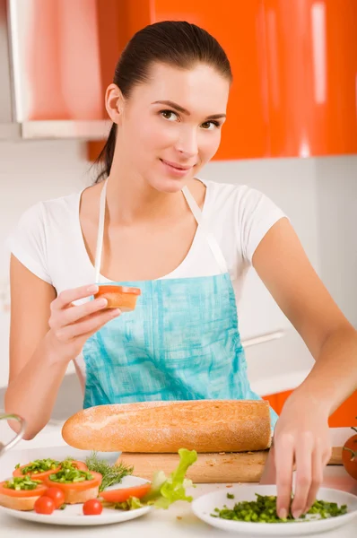Atractiva mujer sonriente preparando sándwiches frescos y saludables en h —  Fotos de Stock