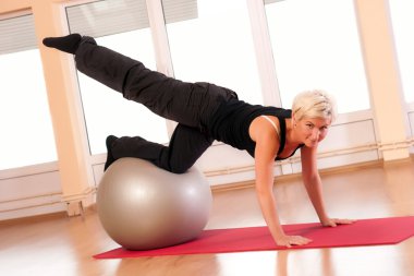 Young woman in sportswear, doing fitness exercise with fit ball. clipart