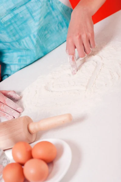 Heart shape on flour, done by woman hands. — Stock Photo, Image