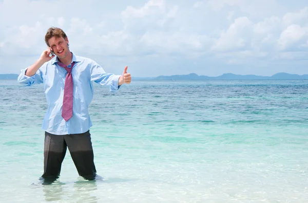 Hombre de negocios llamando por teléfono celular en la playa —  Fotos de Stock