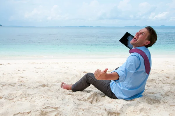 Homem de negócios feliz sentado e trabalhando na praia com tablet — Fotografia de Stock