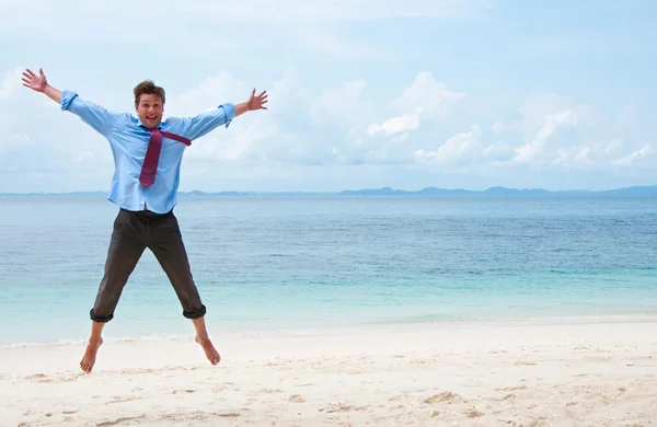 Grappige bedrijf man springen op het strand — Stockfoto