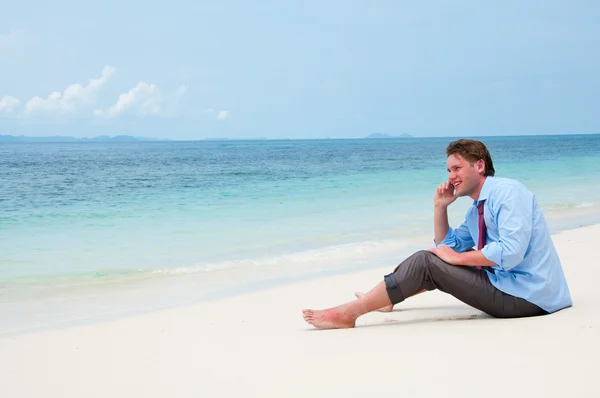 Деловой человек звонит по мобильному телефону на пляже — стоковое фото