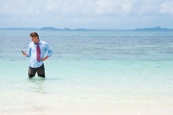 Hombre de negocios llamando por teléfono celular en la playa — Foto de Stock