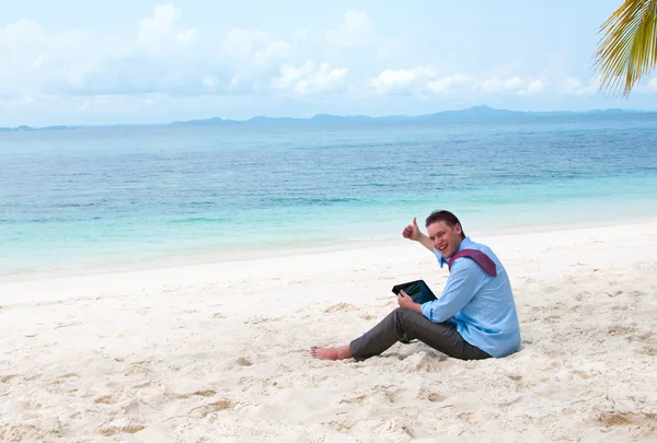 Uomo d'affari seduto e al lavoro sulla spiaggia con tablet comput — Foto Stock