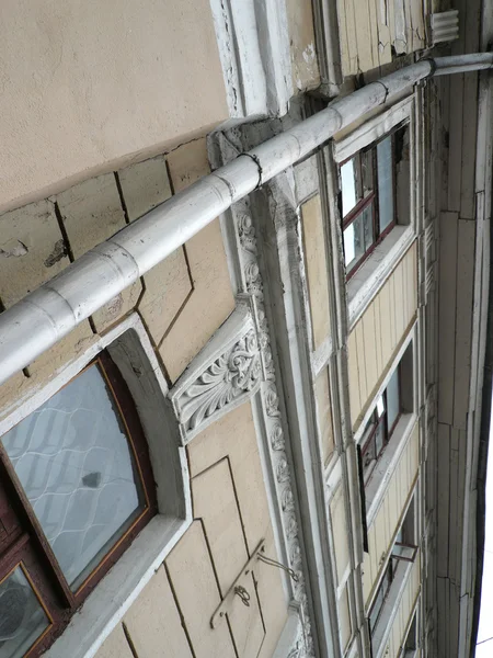 Old yellow building with storm-down pipe — Stock Photo, Image