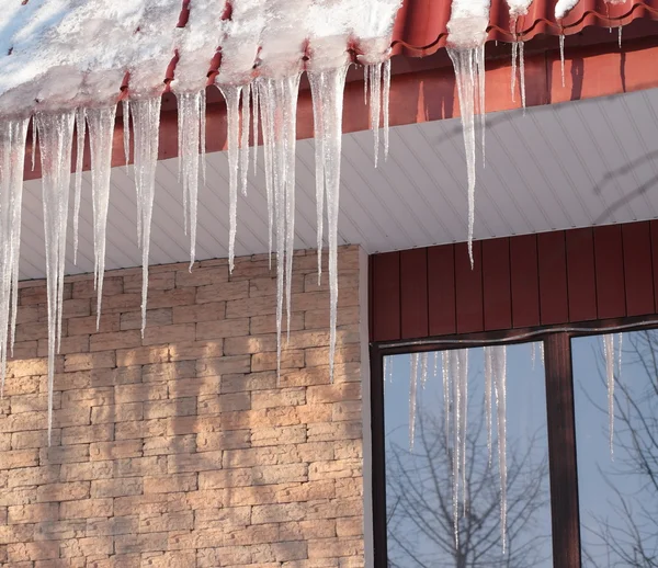 Icicles on building roof at winter day — Stock Photo, Image