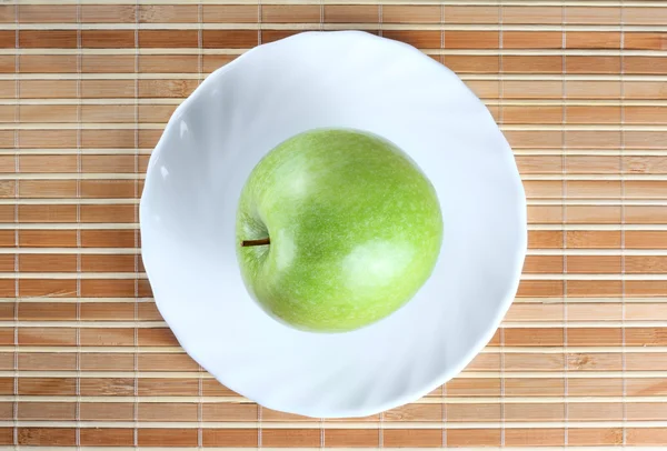 Green apple on the saucer — Stock Photo, Image