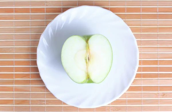 Metade da maçã no prato — Fotografia de Stock