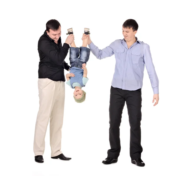 Two gusd holding little boy upside down — Stock Photo, Image
