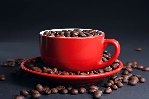 Чашка на блюдце с кофейными зёрнами — стоковое фото