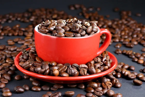 Copo no pires com grãos de café — Fotografia de Stock