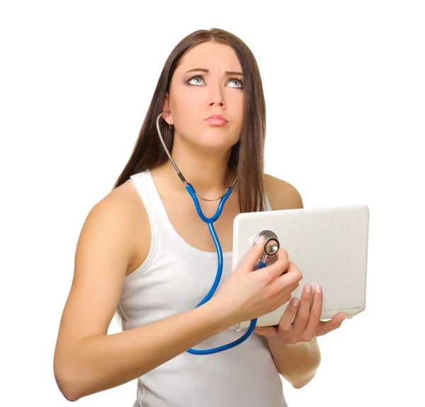 Junges Mädchen hört Laptop mit Stethoskop — Stockfoto