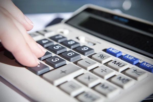 Hand touching calculator in office — Stock Photo, Image