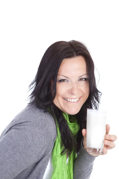 Mujer morena sonriente sosteniendo la leche sobre blanco — Foto de Stock