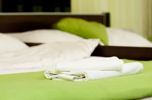 Bílý ručník na hotelovém lůžku — Stock fotografie