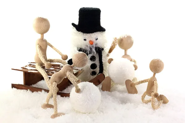 Familias con niños construyendo un muñeco de nieve —  Fotos de Stock