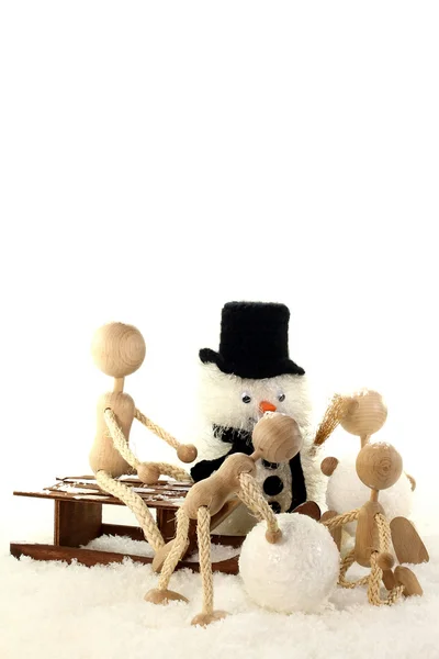 Родители с детьми строят снеговика — стоковое фото