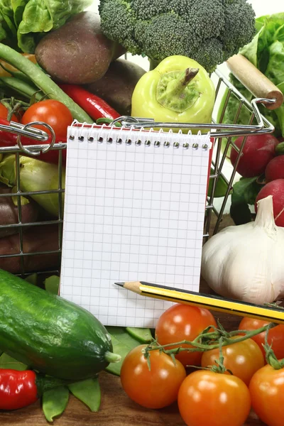 Lista de la compra con lápiz, cesta y verduras — Foto de Stock